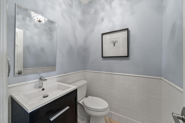 bathroom with vanity, tile walls, and toilet