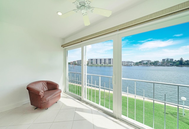 sunroom with a water view and ceiling fan