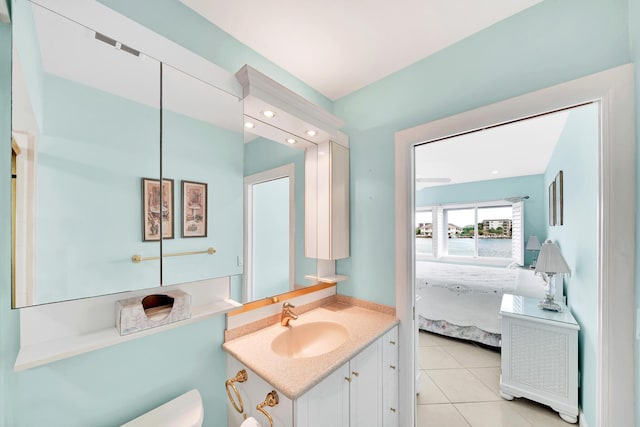 ensuite bathroom featuring toilet, ensuite bath, vanity, and tile patterned floors