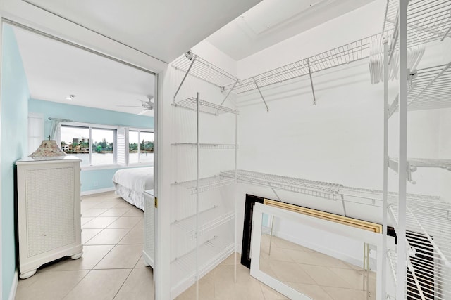 spacious closet with light tile patterned floors and ceiling fan