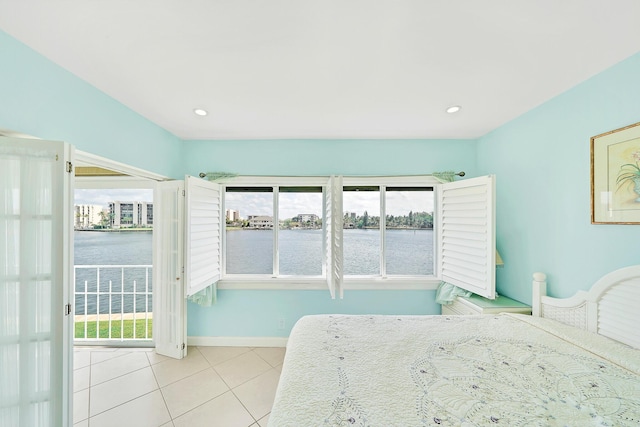 unfurnished bedroom with light tile patterned floors, recessed lighting, a water view, access to outside, and baseboards