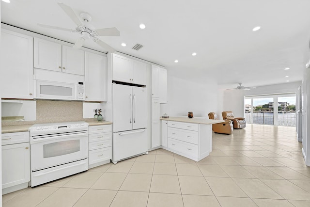 kitchen with white appliances, open floor plan, a peninsula, light countertops, and white cabinetry