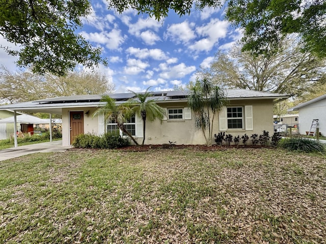 ranch-style home featuring a front lawn and a carport