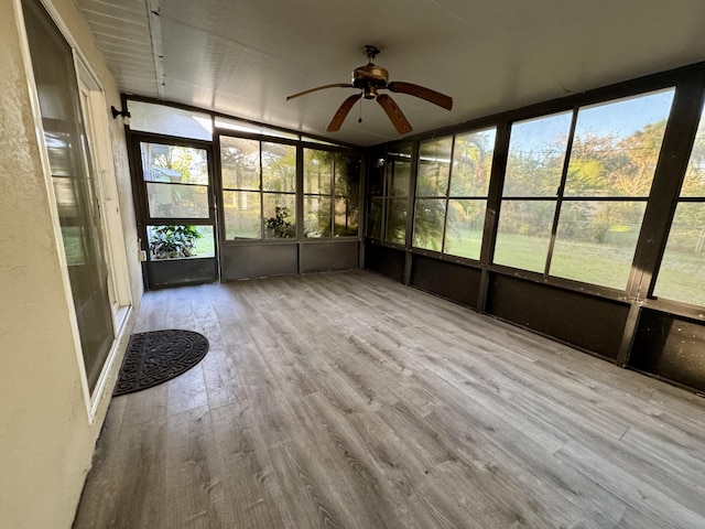 unfurnished sunroom with ceiling fan