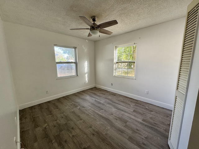 unfurnished bedroom with multiple windows, ceiling fan, a textured ceiling, and dark hardwood / wood-style flooring