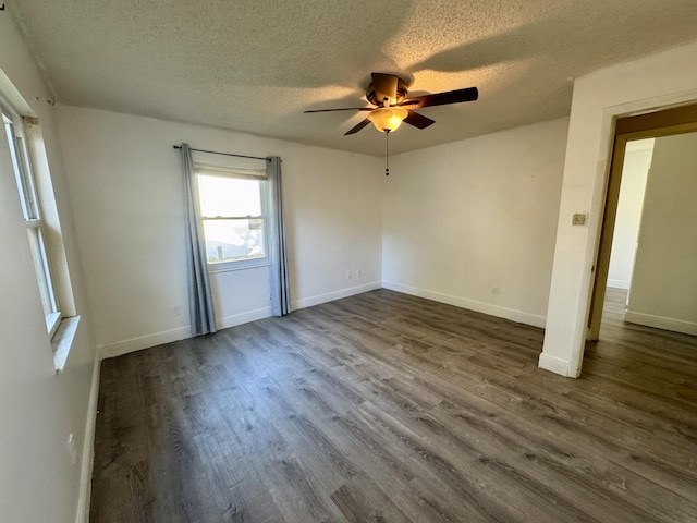 unfurnished room featuring ceiling fan, dark wood-type flooring, and a textured ceiling