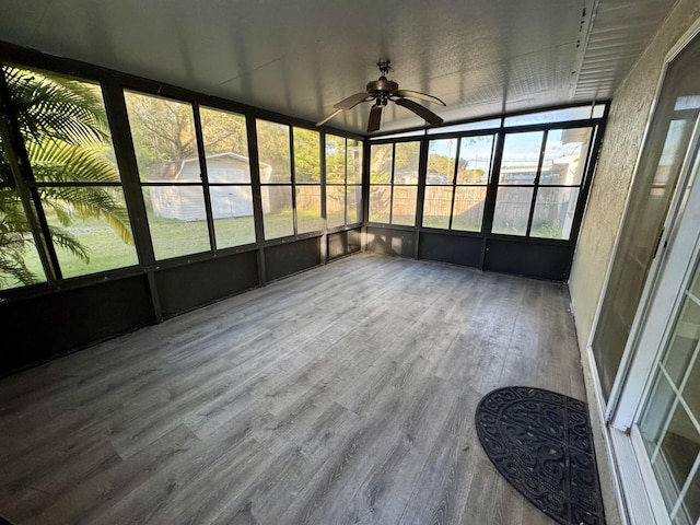 unfurnished sunroom featuring ceiling fan