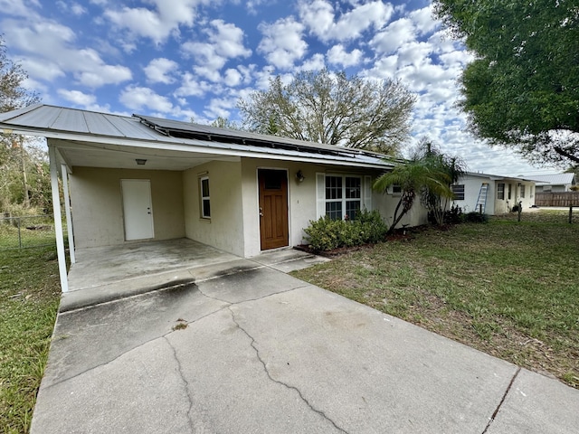 ranch-style home with a front yard and a carport