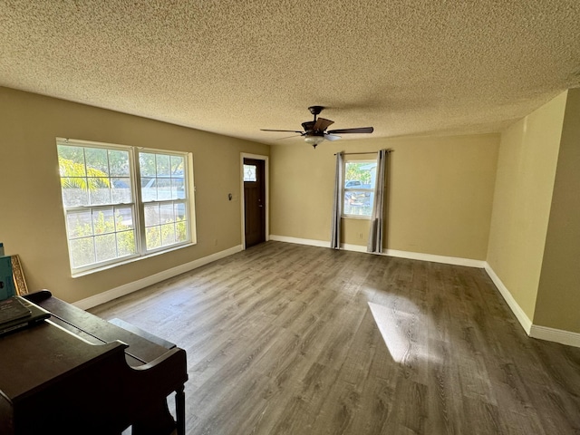 unfurnished living room featuring a textured ceiling, hardwood / wood-style flooring, and ceiling fan