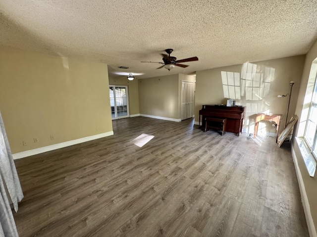 unfurnished living room with a textured ceiling, ceiling fan, and wood-type flooring