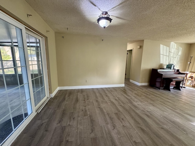 interior space with a textured ceiling and hardwood / wood-style floors