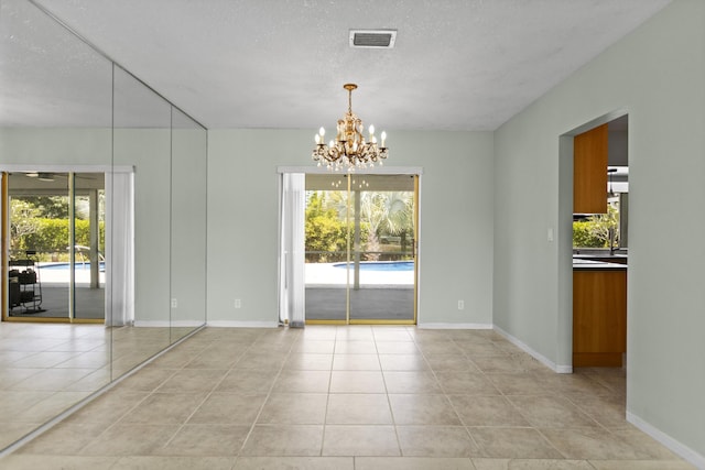 1821 N 50th Ave, Hollywood, FL 33021 - empty room with a chandelier, light tile patterned flooring, baseboards, and a textured ceiling
