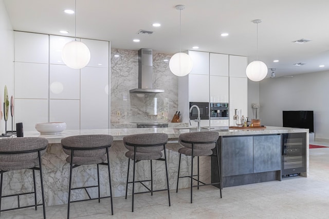 kitchen featuring a sink, visible vents, white cabinets, wall chimney exhaust hood, and modern cabinets