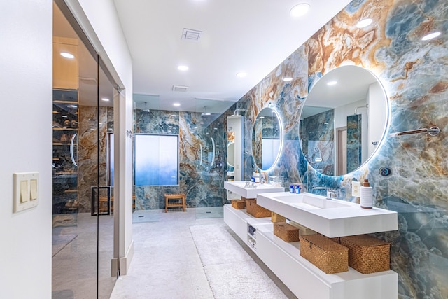 bathroom featuring recessed lighting, a sink, visible vents, tile walls, and a shower with door