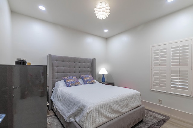 bedroom with baseboards, wood finished floors, and recessed lighting