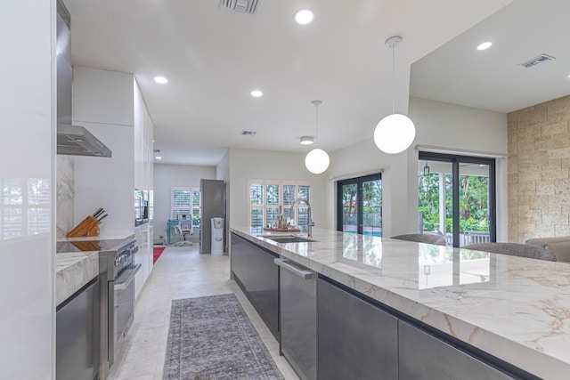 kitchen featuring high end stainless steel range oven, modern cabinets, a sink, and light stone countertops