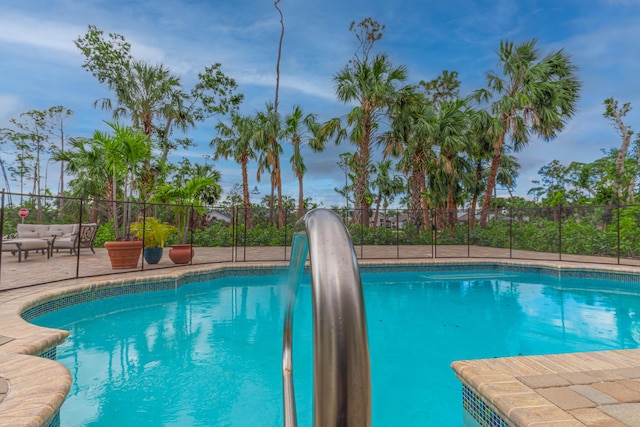 view of pool featuring a water slide, fence, and a fenced in pool