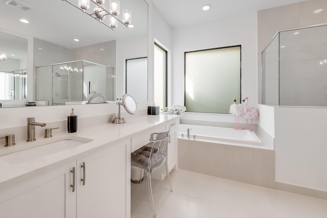 bathroom with a chandelier, independent shower and bath, tile patterned flooring, and vanity