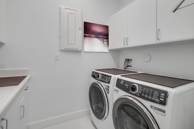 clothes washing area featuring electric panel, washer and dryer, and cabinets