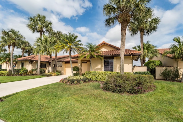 mediterranean / spanish-style home with concrete driveway, a tiled roof, an attached garage, a front lawn, and stucco siding