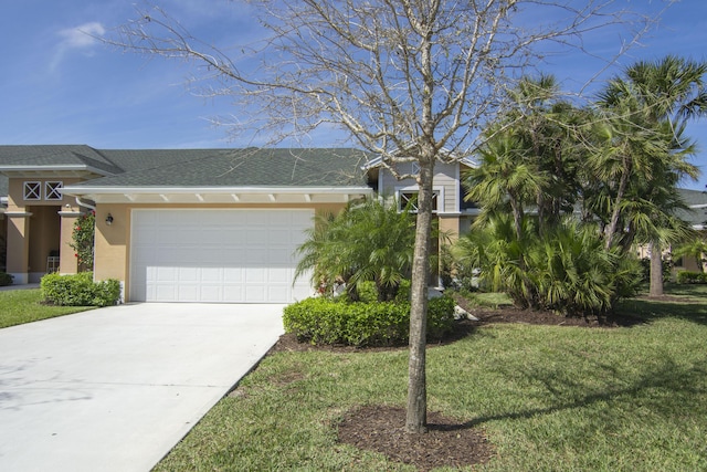 view of front of house with a garage, driveway, roof with shingles, a front lawn, and stucco siding