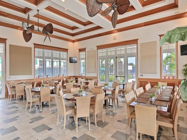 dining room featuring ornamental molding, a high ceiling, beamed ceiling, and coffered ceiling