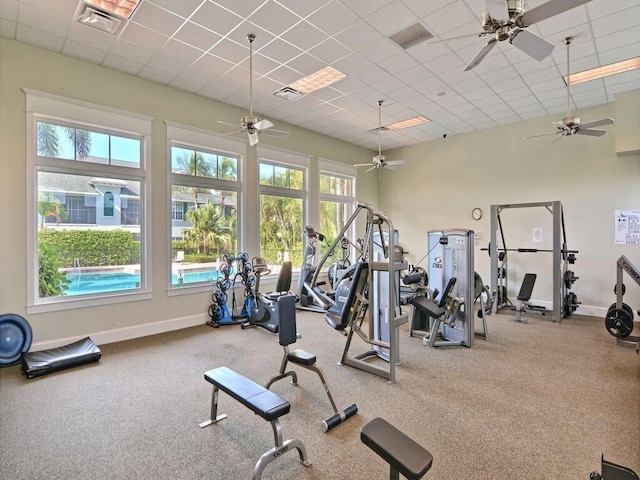 gym with a drop ceiling, visible vents, and baseboards