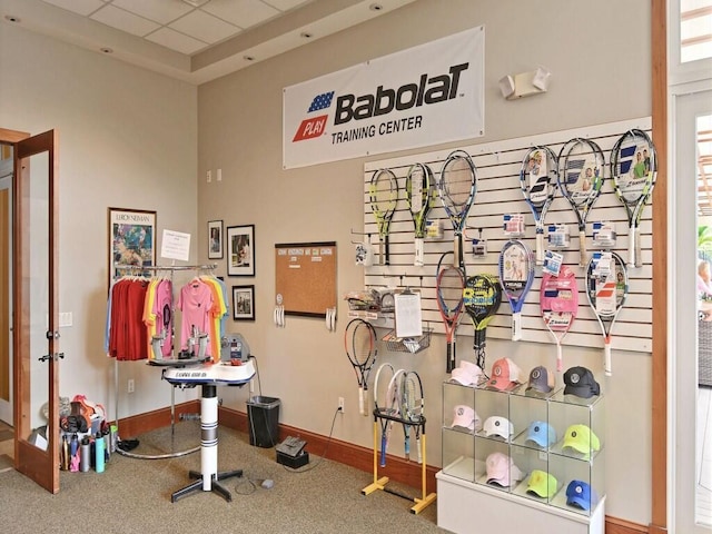 exercise room with a paneled ceiling and baseboards