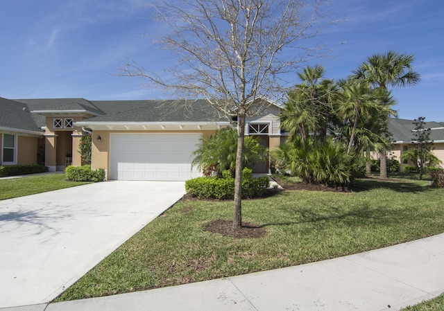 view of front of property with a front lawn, driveway, an attached garage, and stucco siding