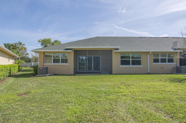 back of property with central air condition unit, a yard, and stucco siding