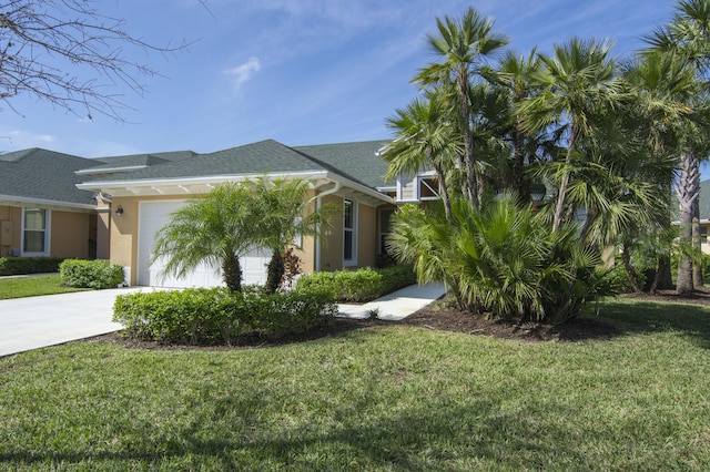 view of front of house featuring a garage, concrete driveway, and a front yard