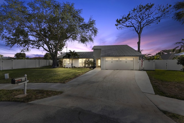 view of front of property with a garage and a lawn