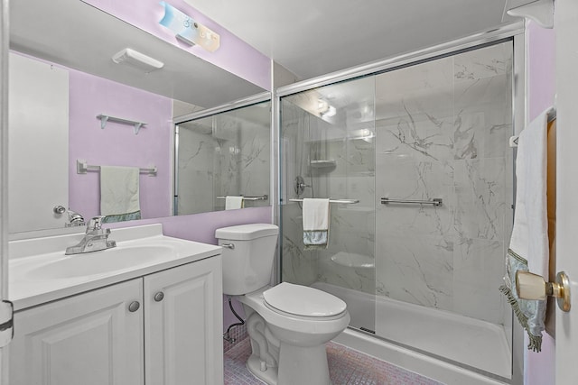 bathroom with a marble finish shower, toilet, and vanity