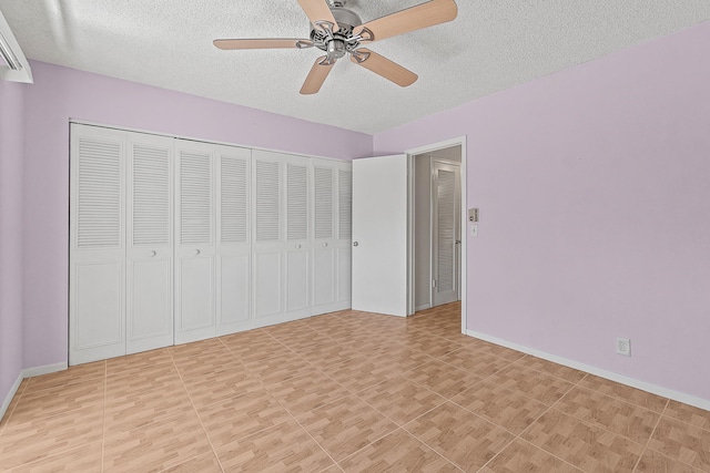 unfurnished bedroom with a closet, a textured ceiling, baseboards, and a ceiling fan