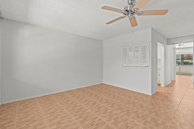 unfurnished room with light tile patterned floors, baseboards, a textured ceiling, and a ceiling fan