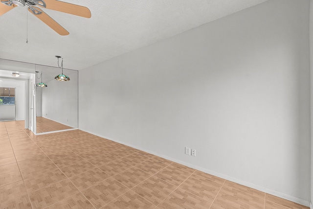 interior space featuring light tile patterned floors, baseboards, a textured ceiling, and ceiling fan