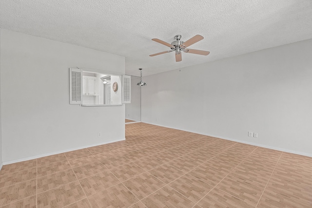 empty room featuring baseboards, a textured ceiling, and ceiling fan