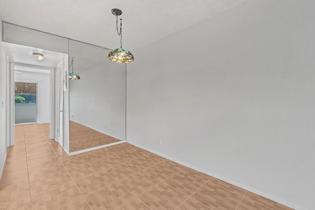 spare room featuring light tile patterned floors and baseboards