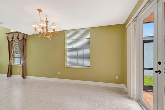 unfurnished room with an inviting chandelier, visible vents, light tile patterned floors, and baseboards