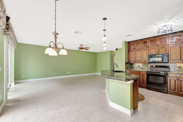 kitchen featuring a sink, dark stone counters, black appliances, brown cabinetry, and pendant lighting