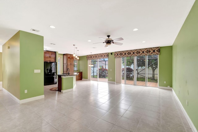 unfurnished living room with visible vents, baseboards, ceiling fan, light tile patterned flooring, and recessed lighting