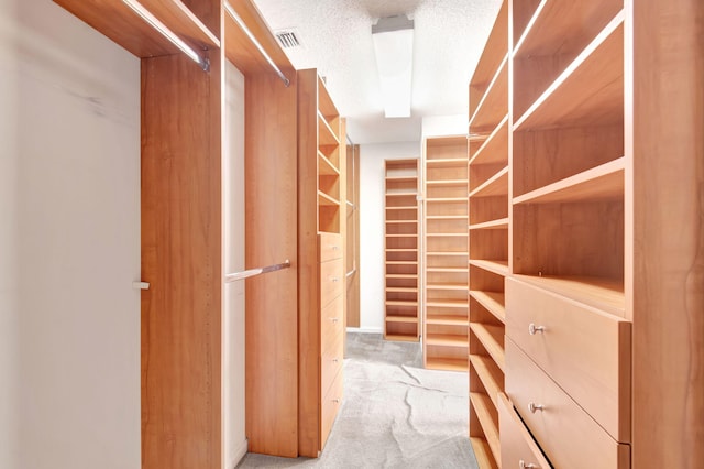 walk in closet featuring light colored carpet and visible vents