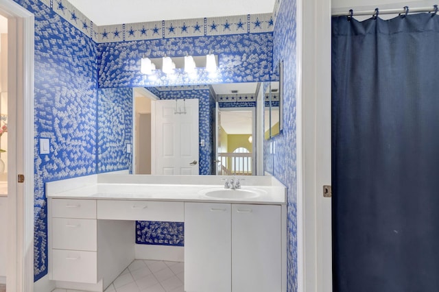 bathroom with tile patterned flooring, vanity, and wallpapered walls