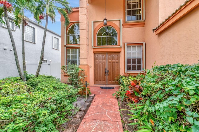 doorway to property featuring stucco siding