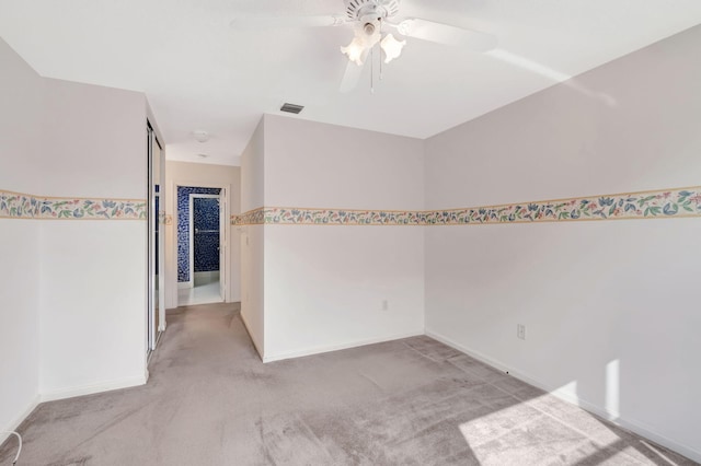 unfurnished room featuring light carpet, baseboards, visible vents, and ceiling fan