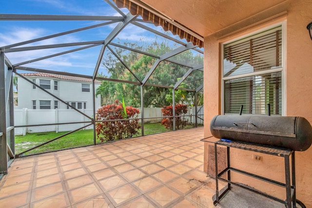 view of patio with glass enclosure and a fenced backyard