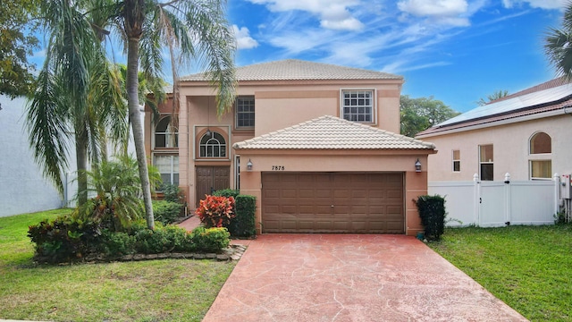 mediterranean / spanish-style house with driveway, a front yard, and stucco siding