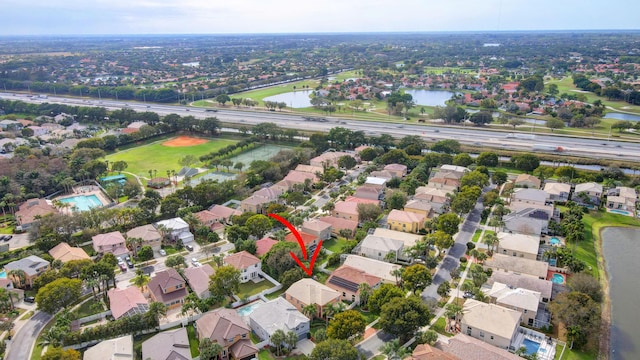 drone / aerial view featuring a water view and a residential view