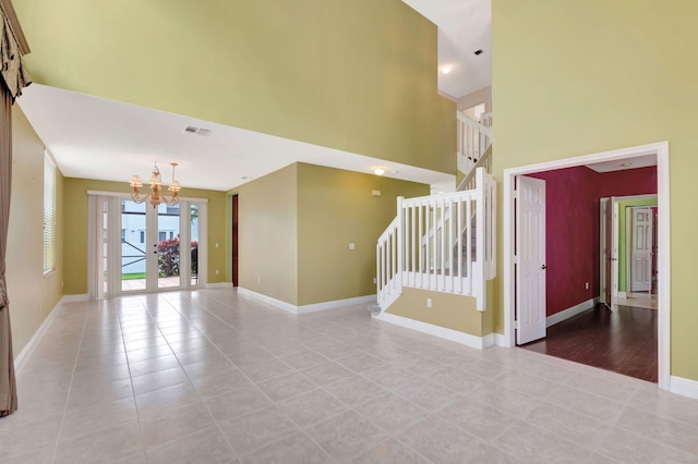 unfurnished room featuring light tile patterned floors, visible vents, baseboards, stairs, and an inviting chandelier