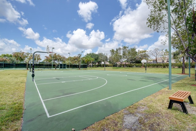 view of basketball court with community basketball court, a lawn, and fence